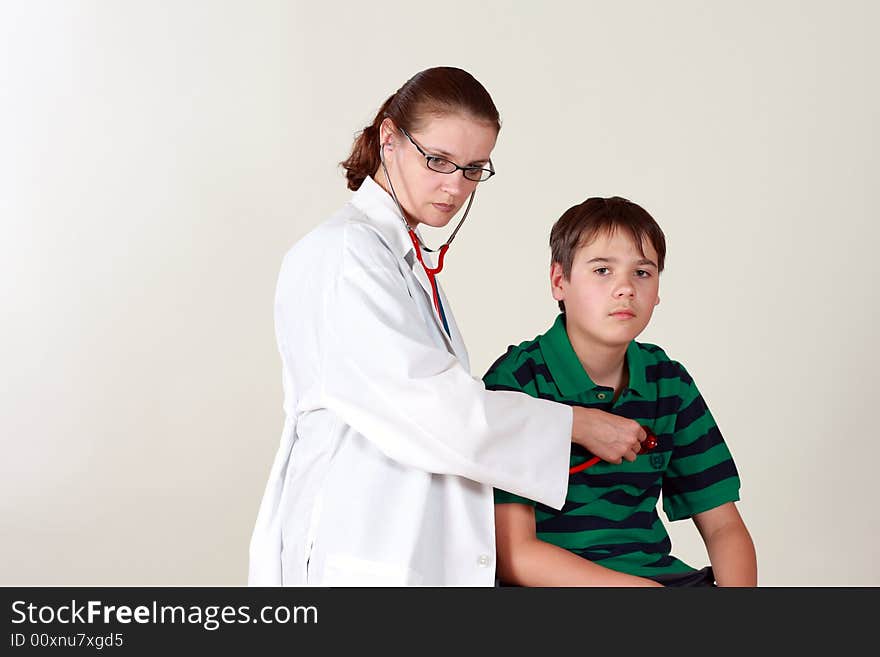 A female doctor examines a child patient using a stethoscope. A female doctor examines a child patient using a stethoscope