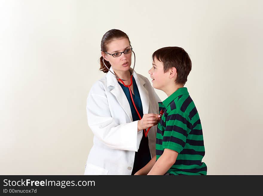 A female doctor examines a child patient using a stethoscope. A female doctor examines a child patient using a stethoscope