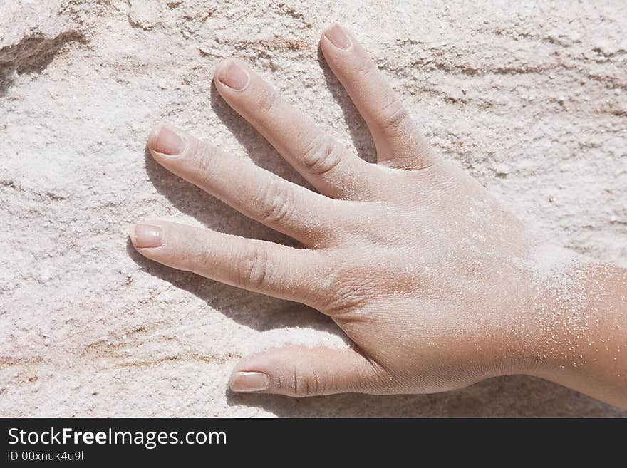 Hand on pink sand wall