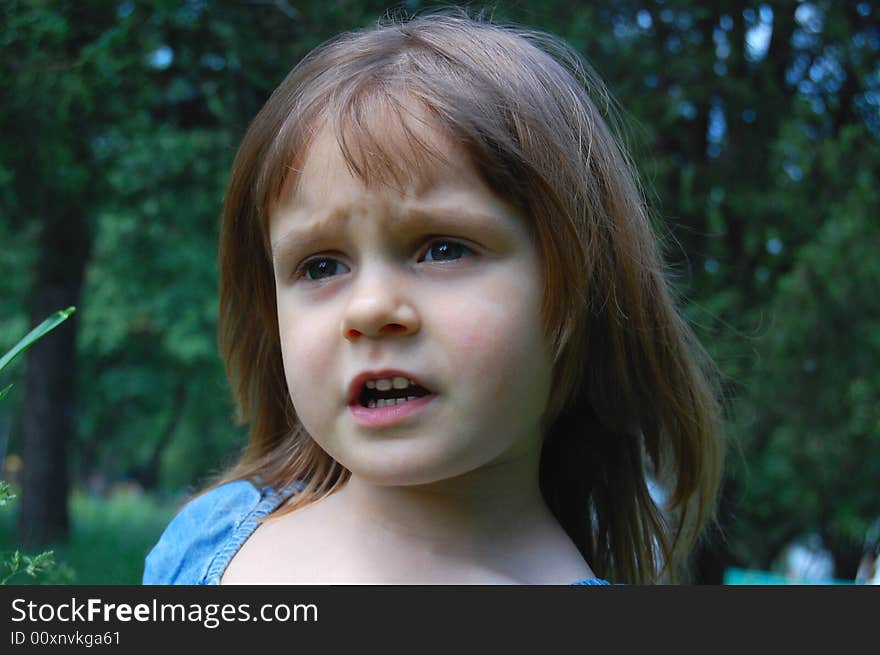 Smiling little pretty girl sitting in grass. Smiling little pretty girl sitting in grass