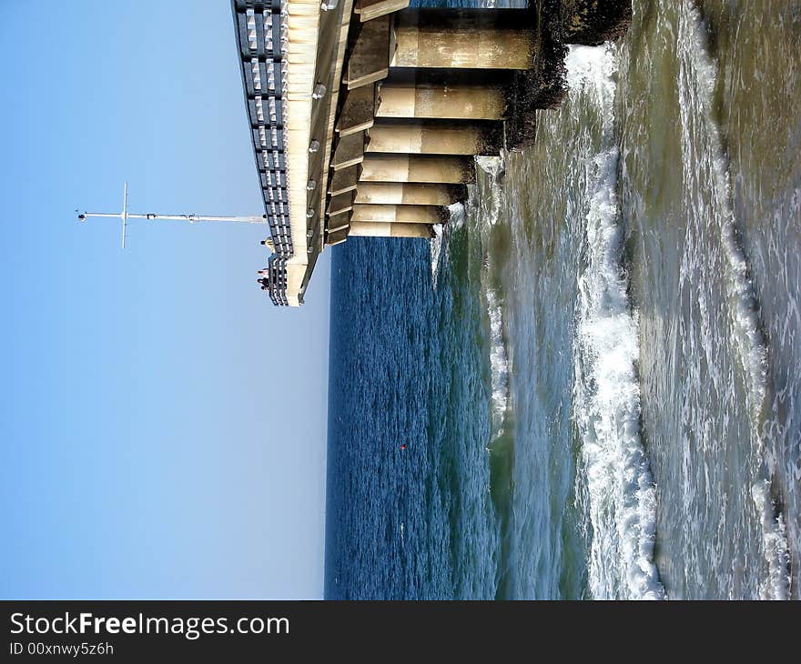 A large pier at the beach stretching into the sea. A large pier at the beach stretching into the sea