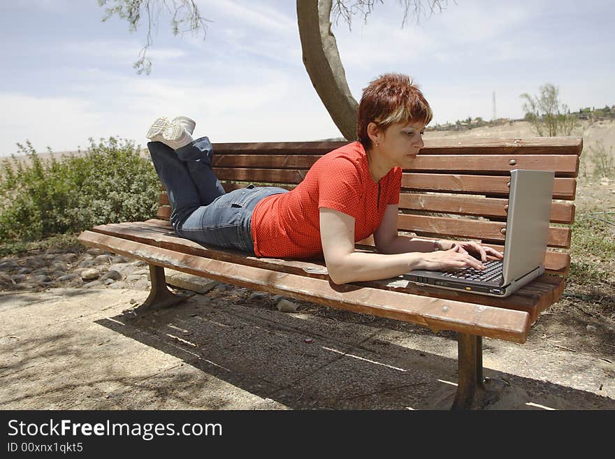 A young woman using a portable computer outside. A young woman using a portable computer outside