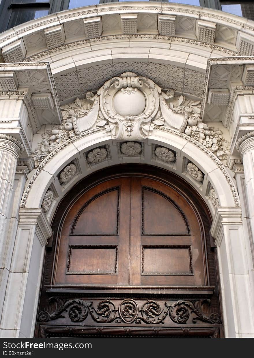 Corinthian architectural detail above wooden door. Corinthian architectural detail above wooden door.