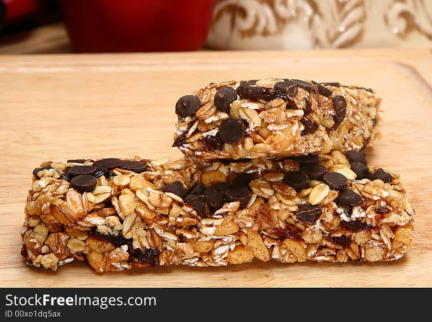 Two organic oat honey and chocolate chip snack bars in kitchen. Two organic oat honey and chocolate chip snack bars in kitchen.