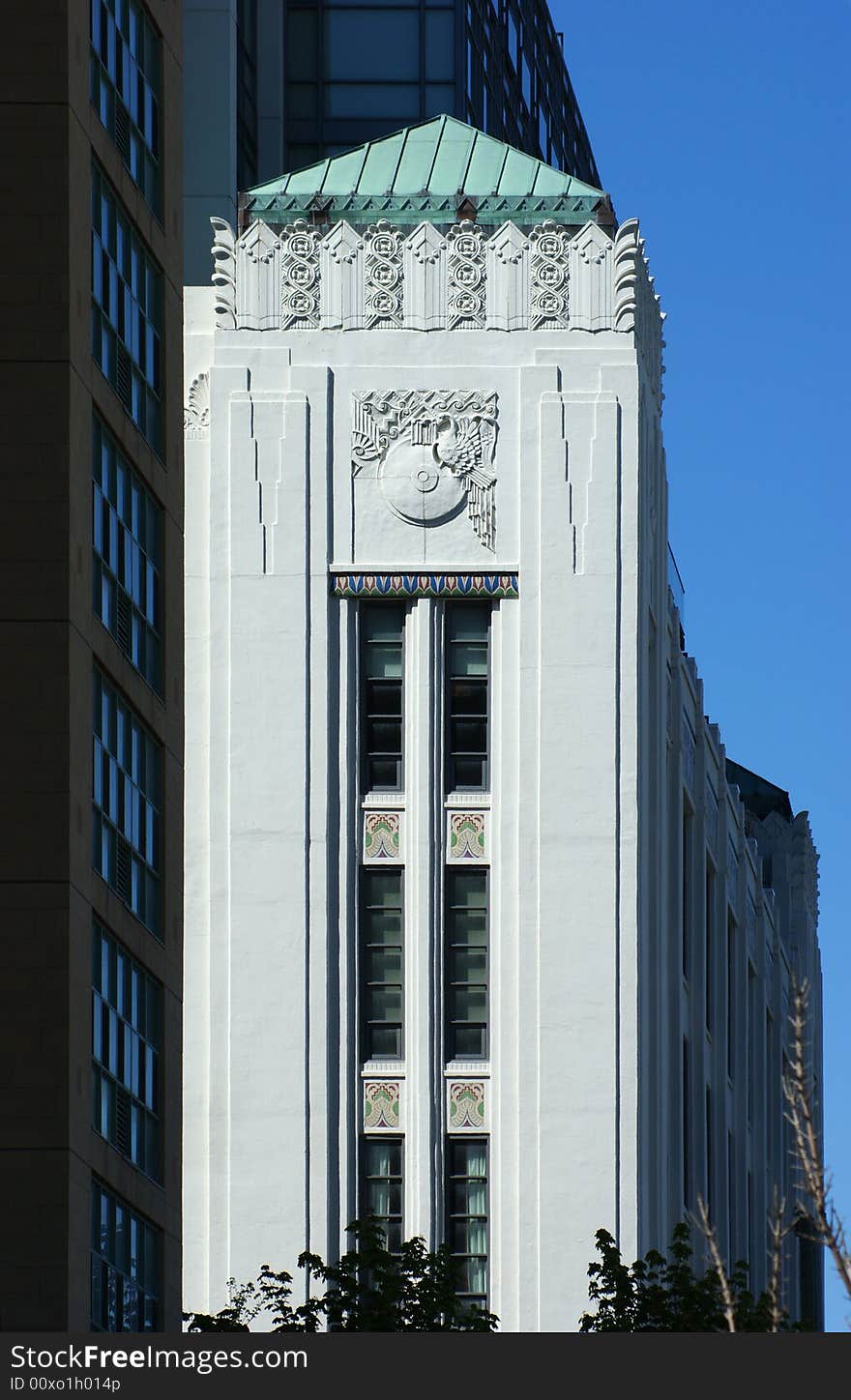 Art deco ornament along top of white wall in tower-like corner detail. Art deco ornament along top of white wall in tower-like corner detail