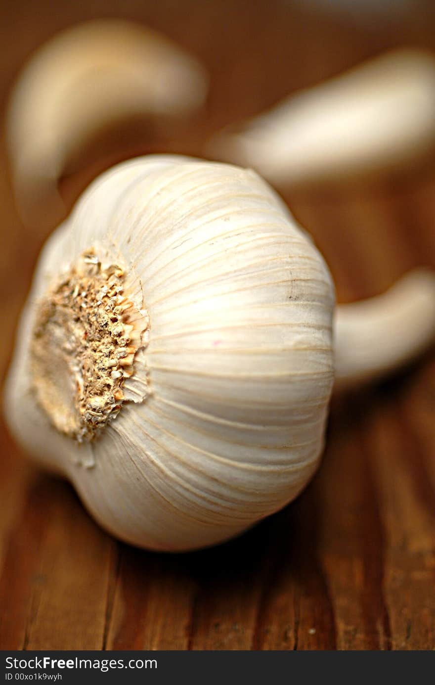 Whole garlic and garlic cloves on textured wood