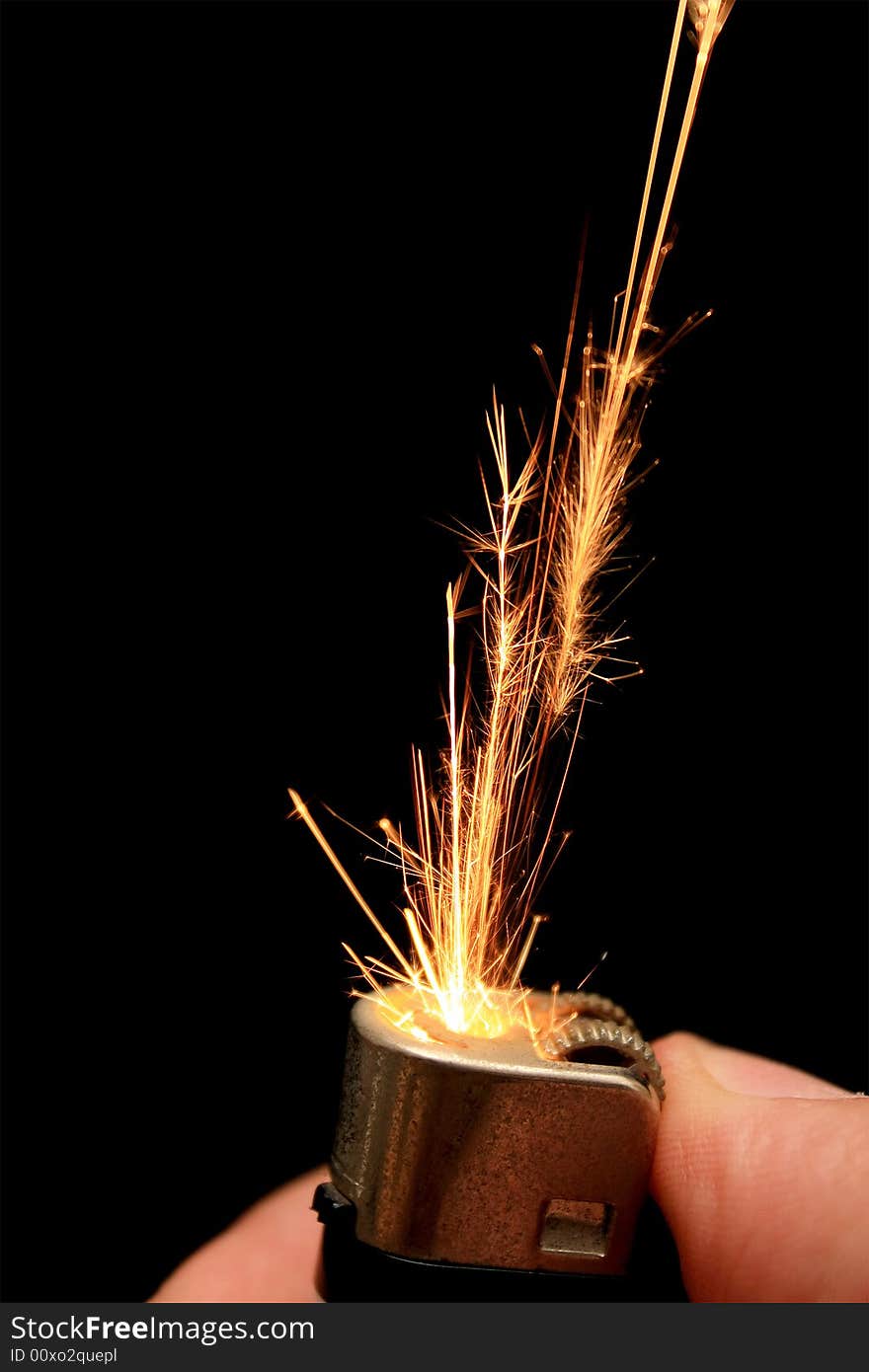 Lighter sparkles on a dark background with human hand.