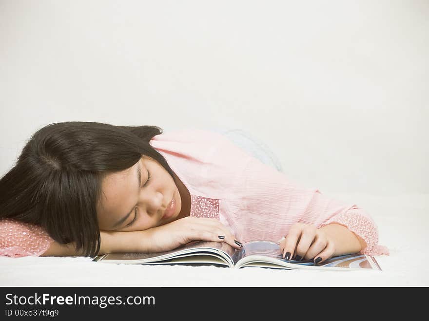 Young, Asian woman falls asleep while reading