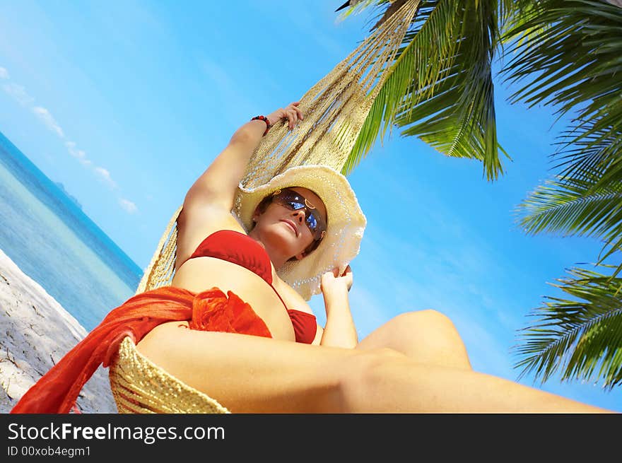 View of nice woman lounging in hammock in tropical environment. View of nice woman lounging in hammock in tropical environment