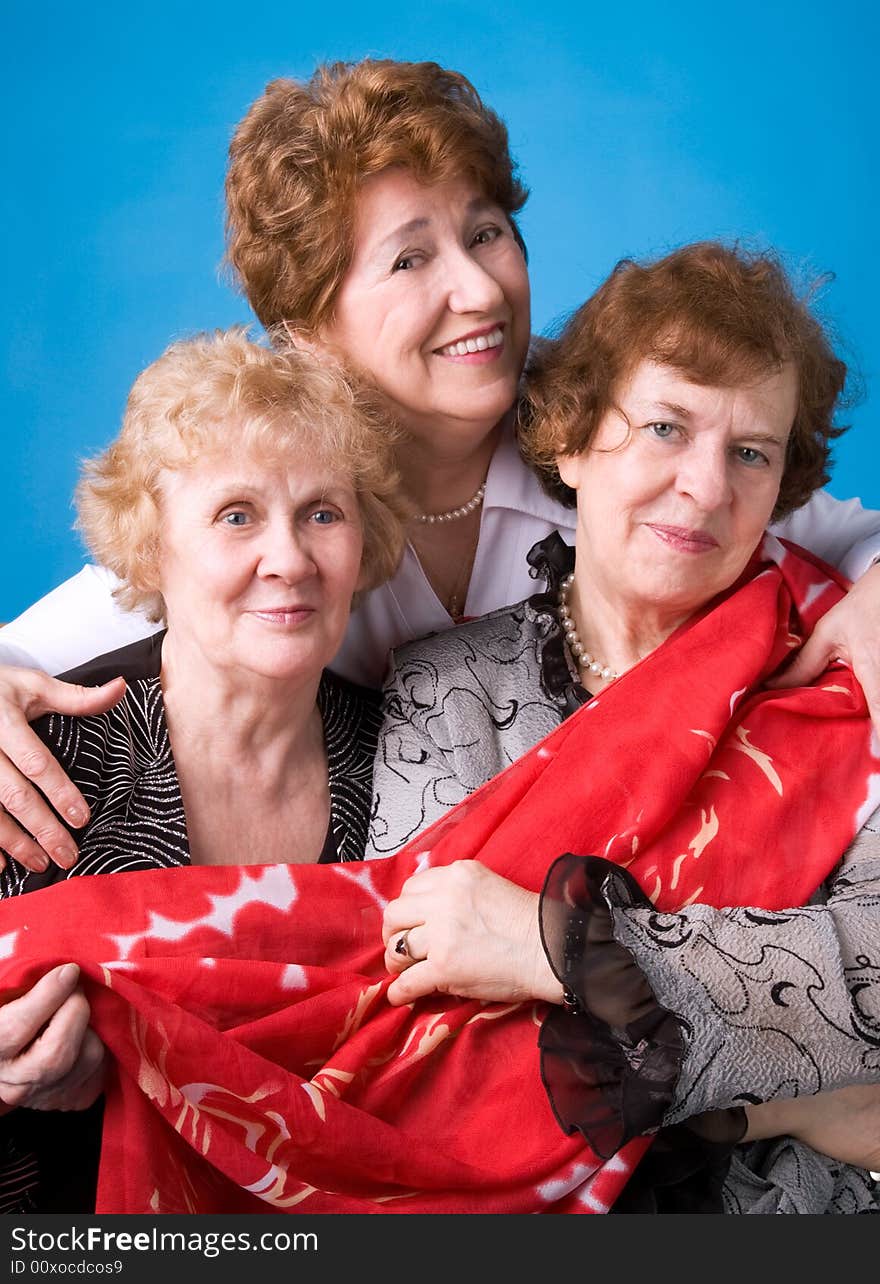 A portrait of three cheerful elderly women on a dark blue background. A portrait of three cheerful elderly women on a dark blue background.