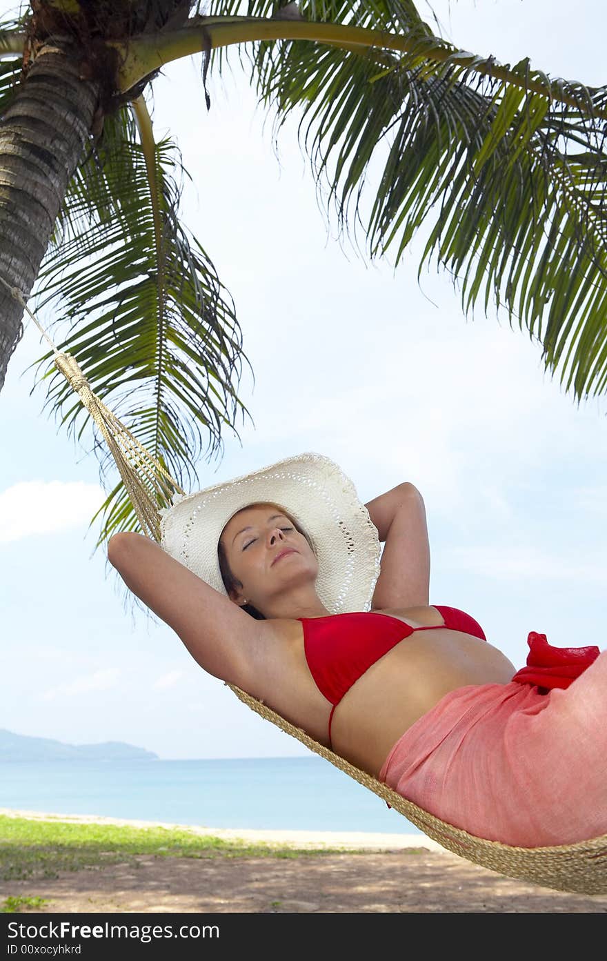 View of nice woman lounging in hammock in tropical environment. View of nice woman lounging in hammock in tropical environment