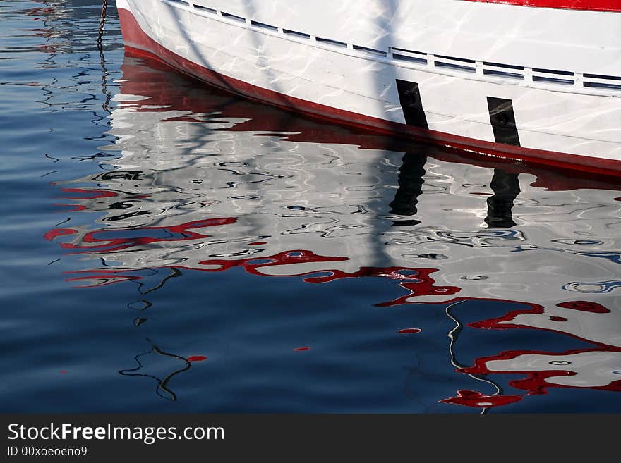 Reflections of a wooden boat in the harbour water. Reflections of a wooden boat in the harbour water