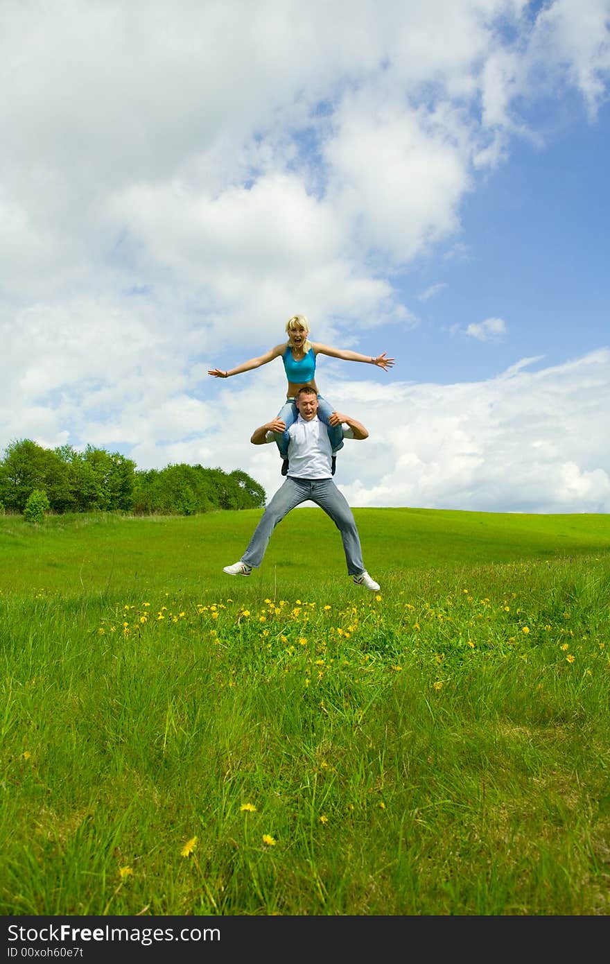 Young family jumping on a lawn