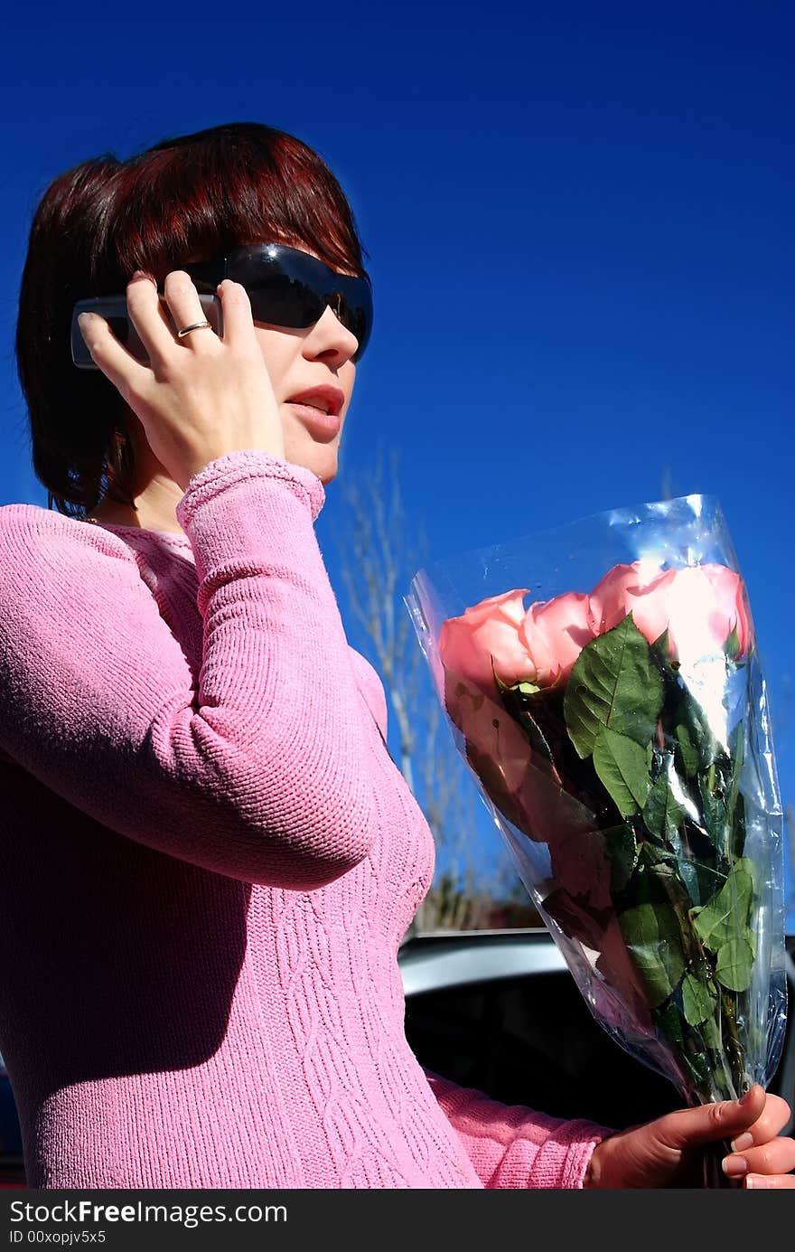 The young, beautiful woman speaks by phone