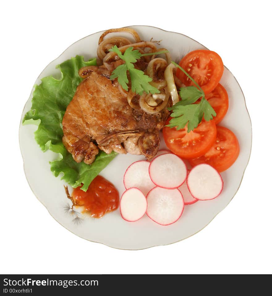 Pork chop with vegetables and sauce of chili on a dish