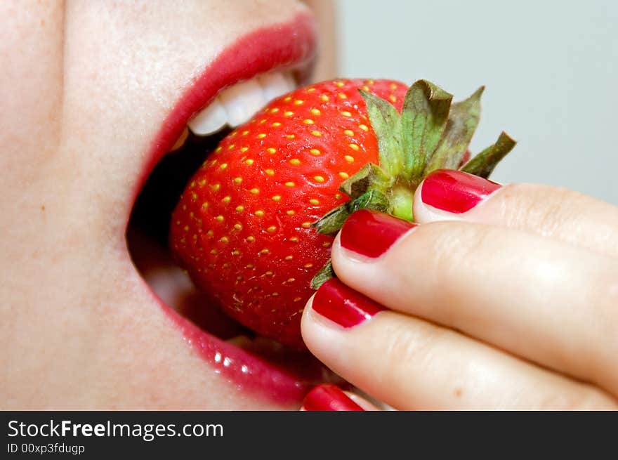 A girl, eating a strawberry, in macro mode. A girl, eating a strawberry, in macro mode