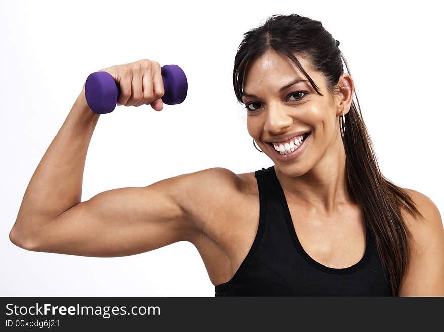 Beautiful brunette woman exercising on a blue mat with purple dum bells