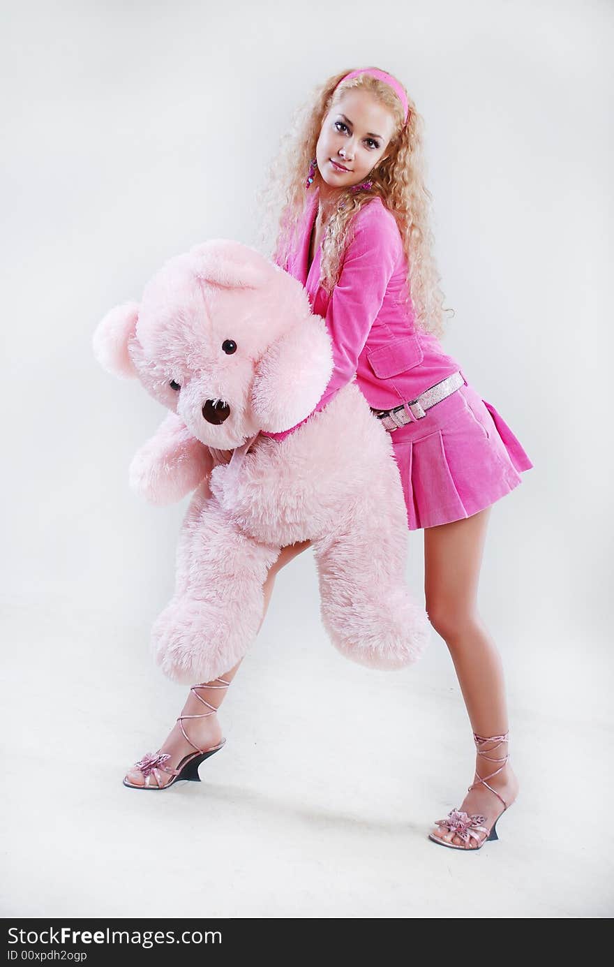 The girl dressed in pink with a teddy-bear in hands. The girl dressed in pink with a teddy-bear in hands