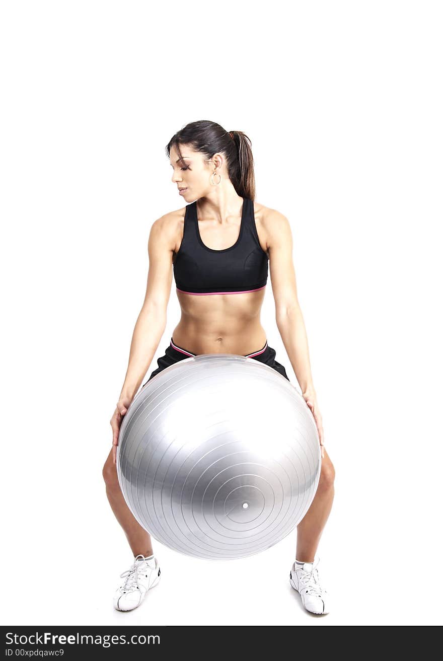 Beautiful brunette woman exercising with a gray yoga ball