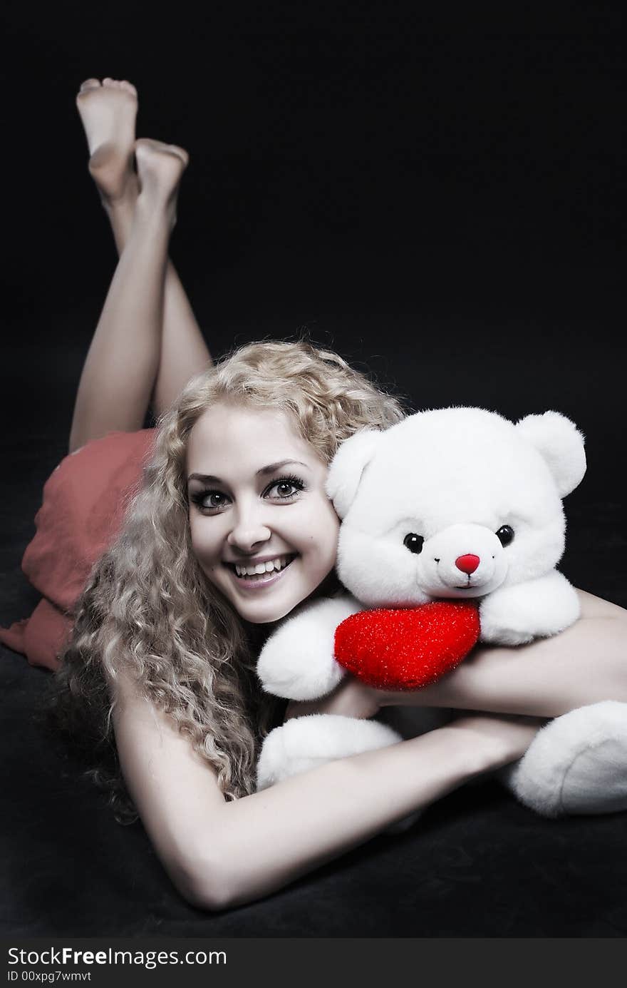 The girl laying embraces the teddy-bear. The girl laying embraces the teddy-bear