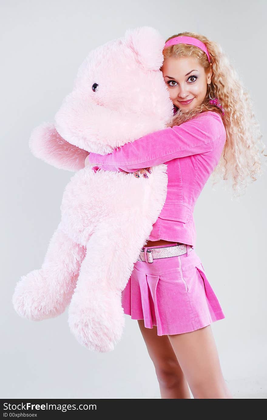 The girl dressed in pink with a teddy-bear in hands. The girl dressed in pink with a teddy-bear in hands