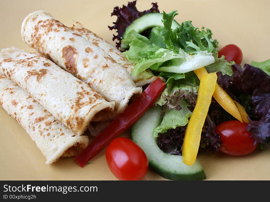 Barbeque Chicken pancakes and fresh salad on a yellow plate. Barbeque Chicken pancakes and fresh salad on a yellow plate