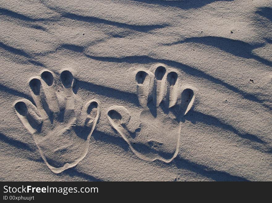 Two child's hand stamp on the sand