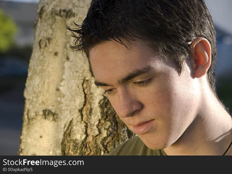 A young man looking down deep in thought. A young man looking down deep in thought