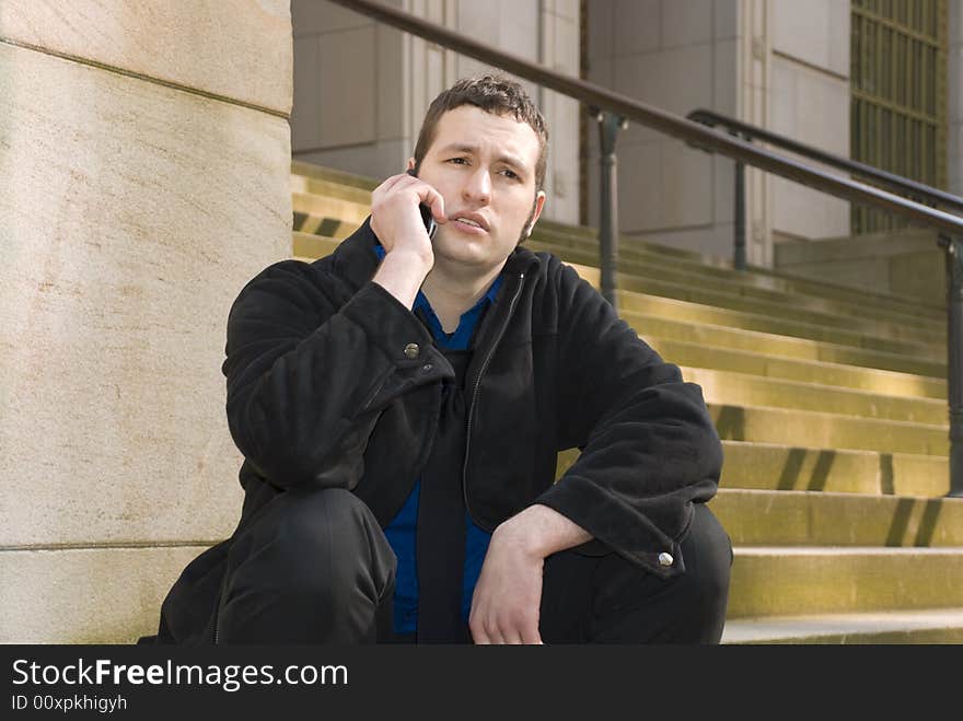 Business guy sitting on the steps outside of a building. Business guy sitting on the steps outside of a building.