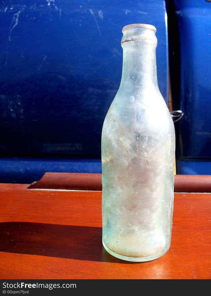 Frosted glass bottle sitting on a wooden shelf