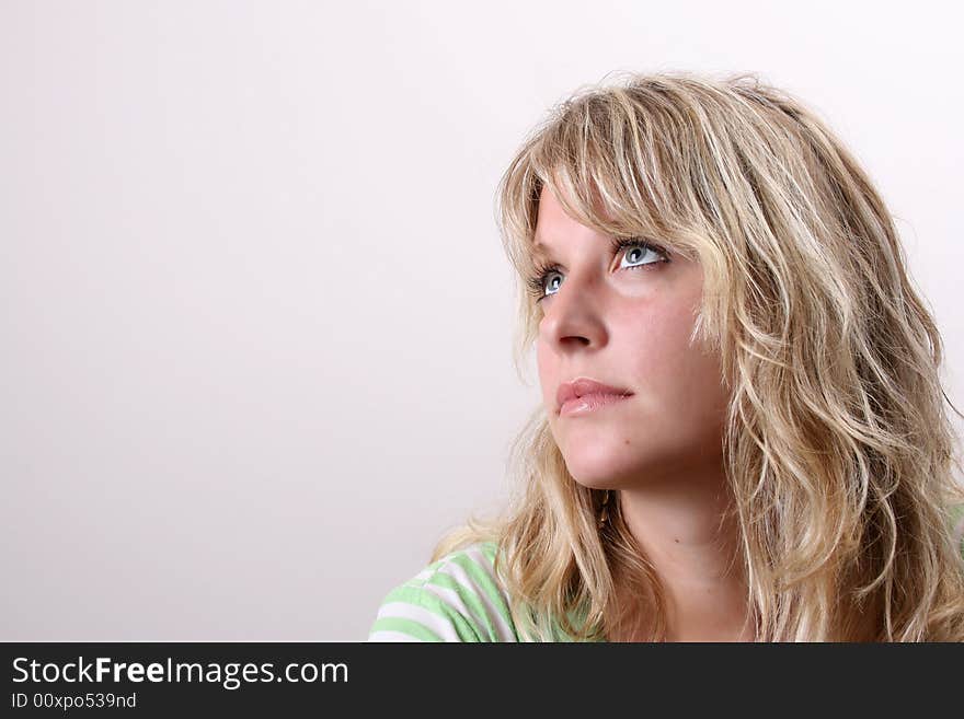 Blond Female model on a white background wearing a green top. Blond Female model on a white background wearing a green top