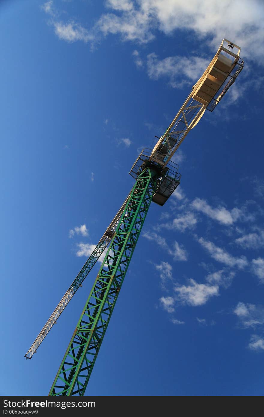 Construction crane against cloudy blue sky