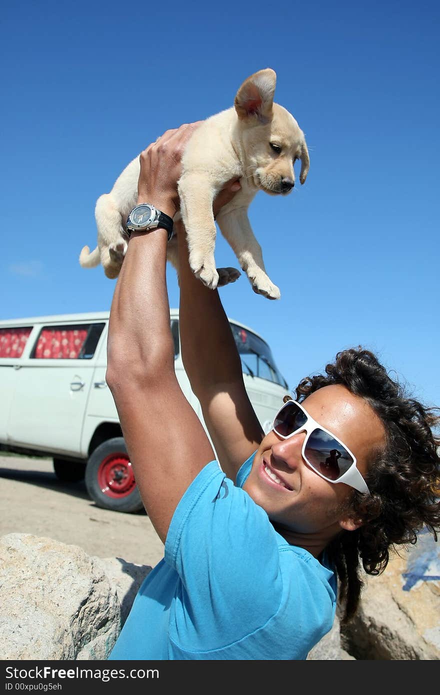 Young man holding his labrador puppy. Young man holding his labrador puppy