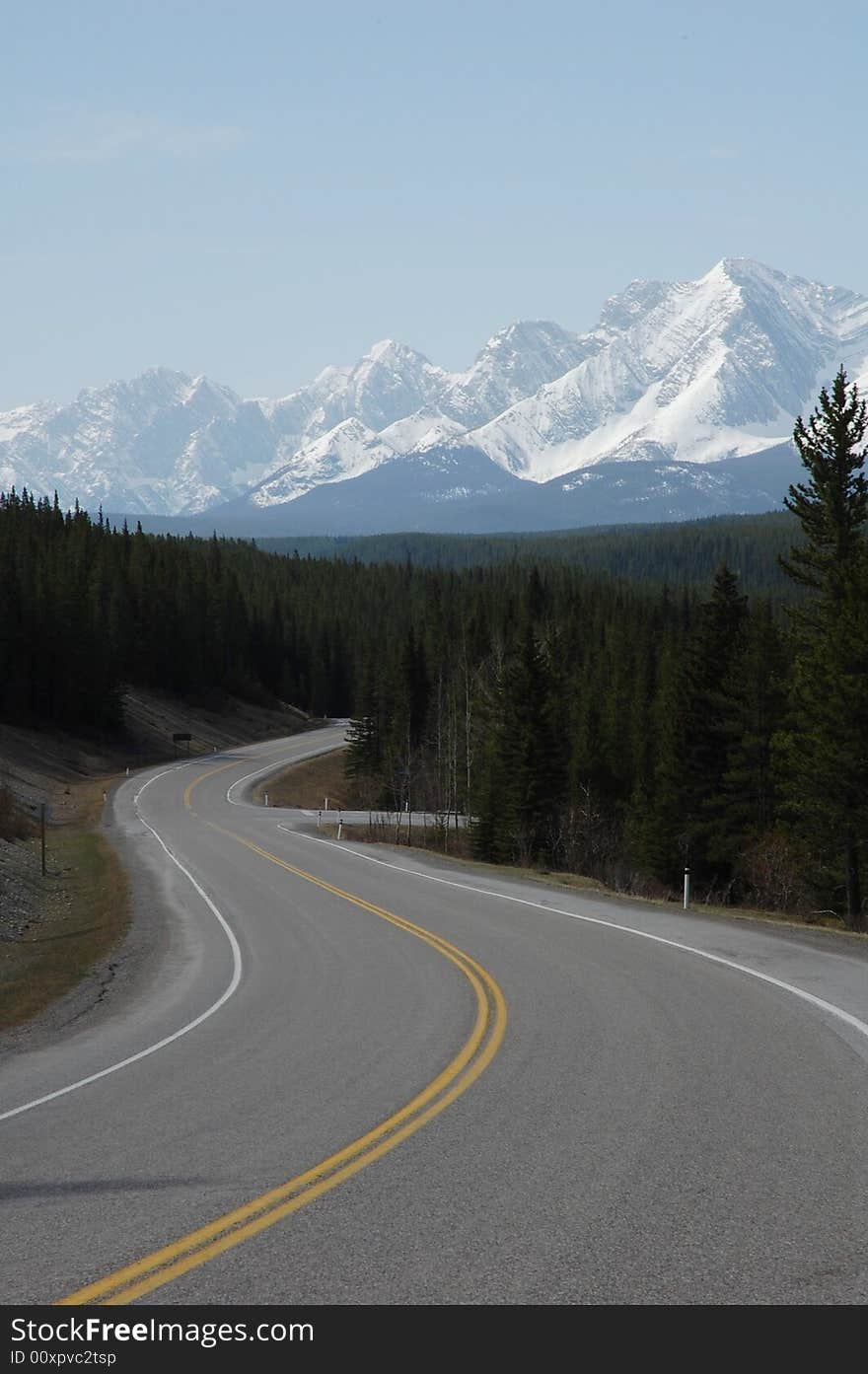 View of snow mountain and winding highway in kananaskis county, alberta, canada