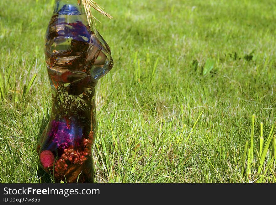 Glass woman with flowers on a background of green grass. Glass woman with flowers on a background of green grass