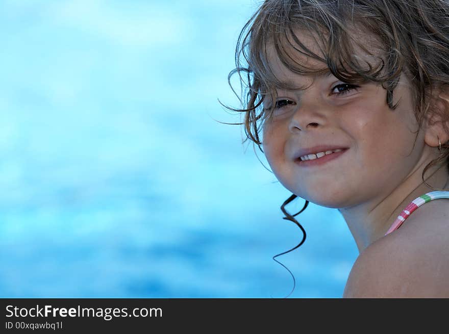 A young girl looking at camera buy a pool. A young girl looking at camera buy a pool