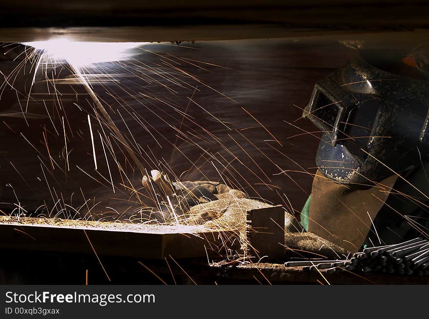 A welder working at shipyard during night shift. A welder working at shipyard during night shift