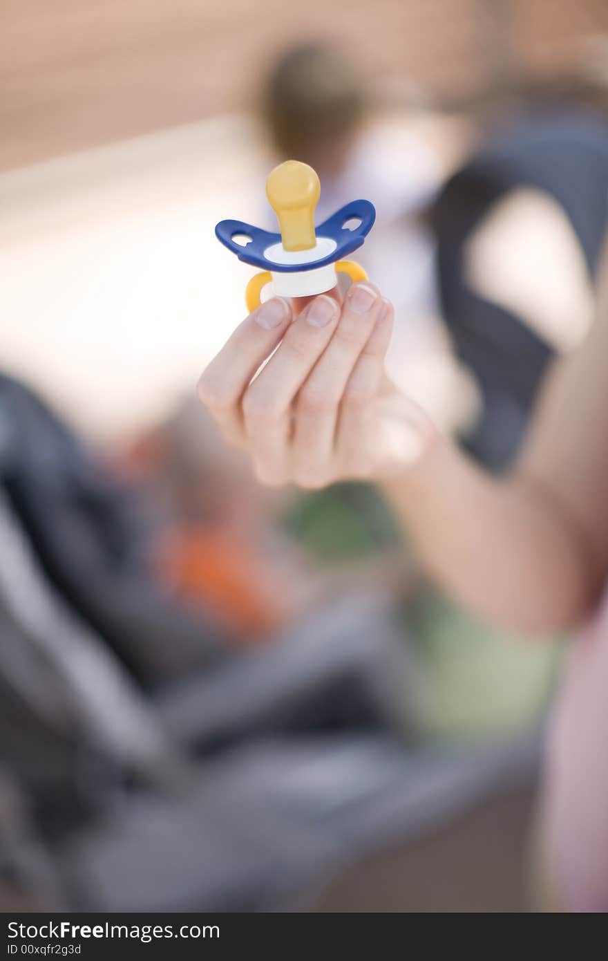 Woman holding blue binky in hand. Woman holding blue binky in hand