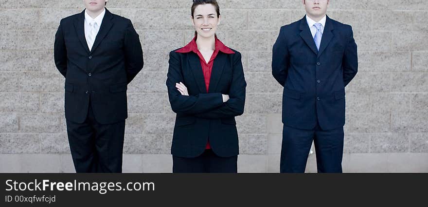 Attractive businesswoman stands between two businessmen. Attractive businesswoman stands between two businessmen