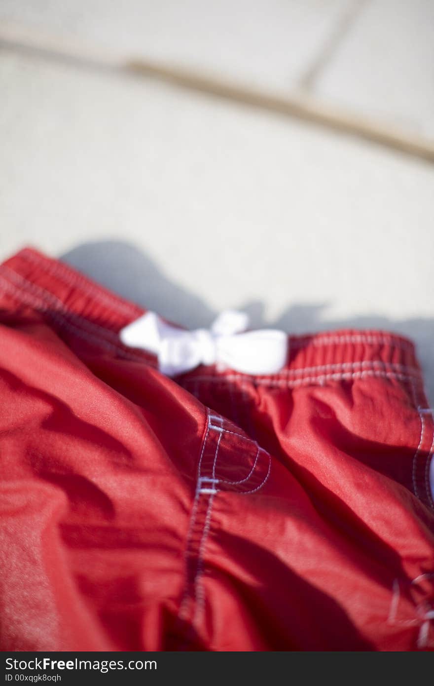 Small red shorts with white knot with tan background