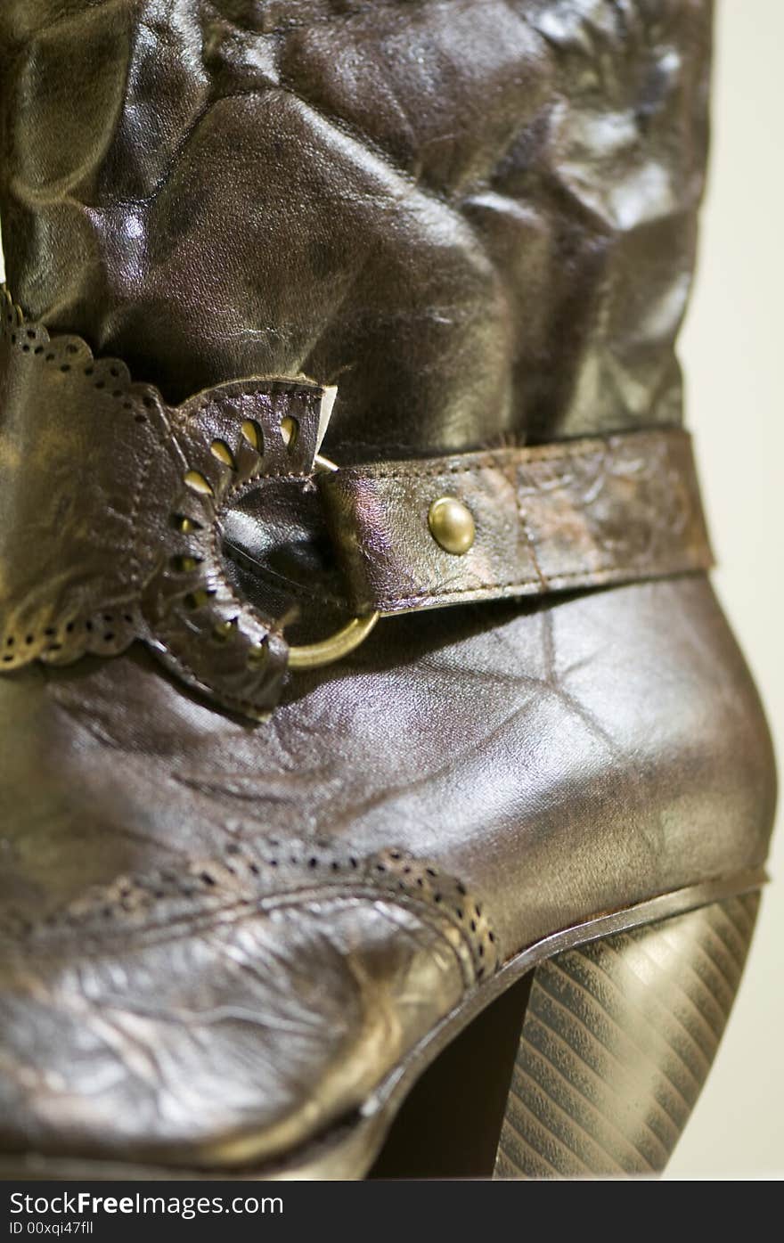 A pair of ladies boots manufactured from synthetic 'leather' with buckle and midi heel. The texture of the fabric can be seen. A pair of ladies boots manufactured from synthetic 'leather' with buckle and midi heel. The texture of the fabric can be seen.