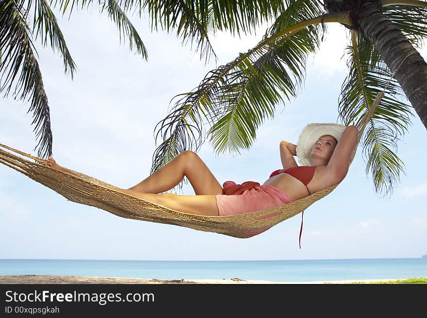 View of nice woman lounging in hammock in tropical environment. View of nice woman lounging in hammock in tropical environment