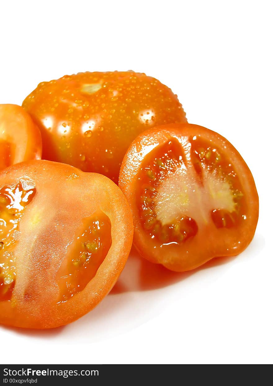 Bunch of tomatoes isolated on a white background, sliced and with droplets of water.