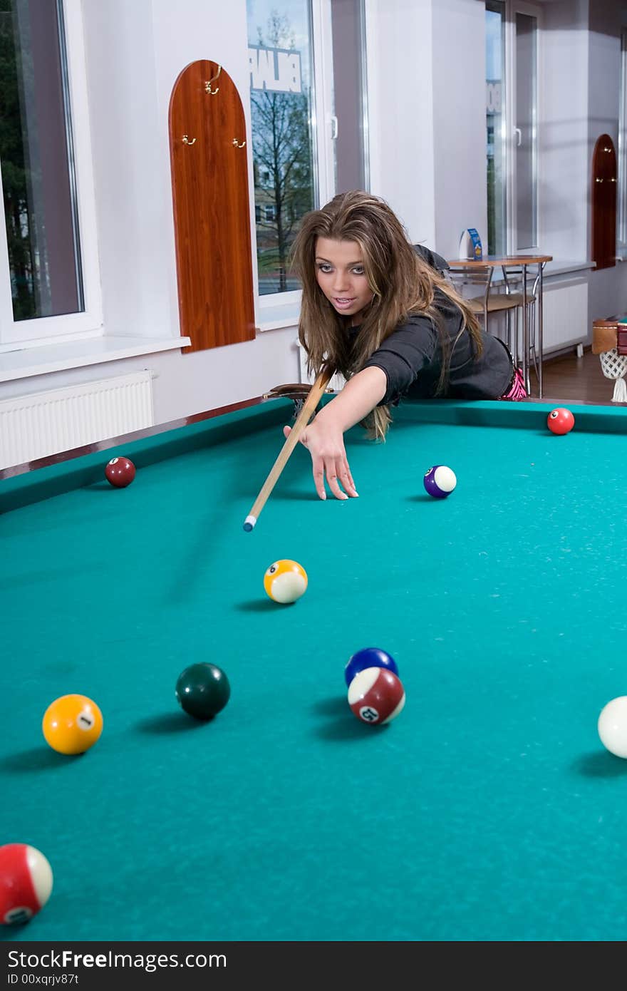 Young girl in short skirt playing snooker