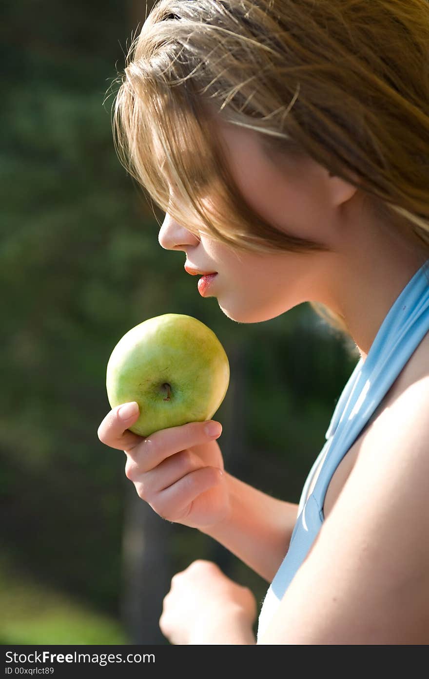 Girl with apple on sunset