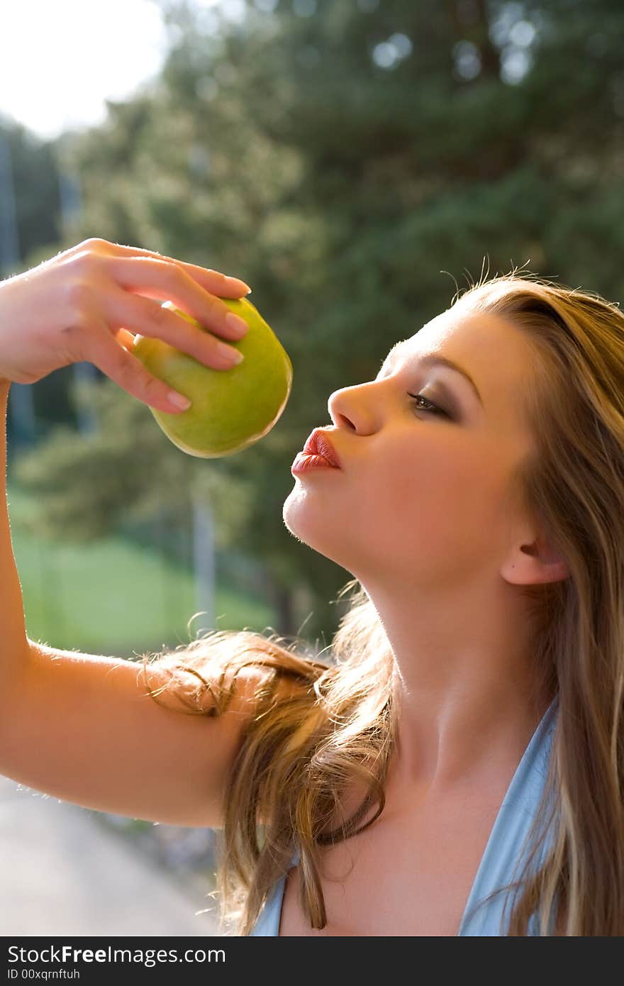 Girl with apple on sunset