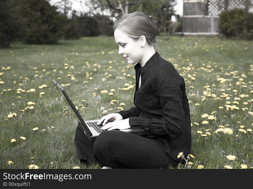 Young Woman Working On Computer In The Garden. Young Woman Working On Computer In The Garden