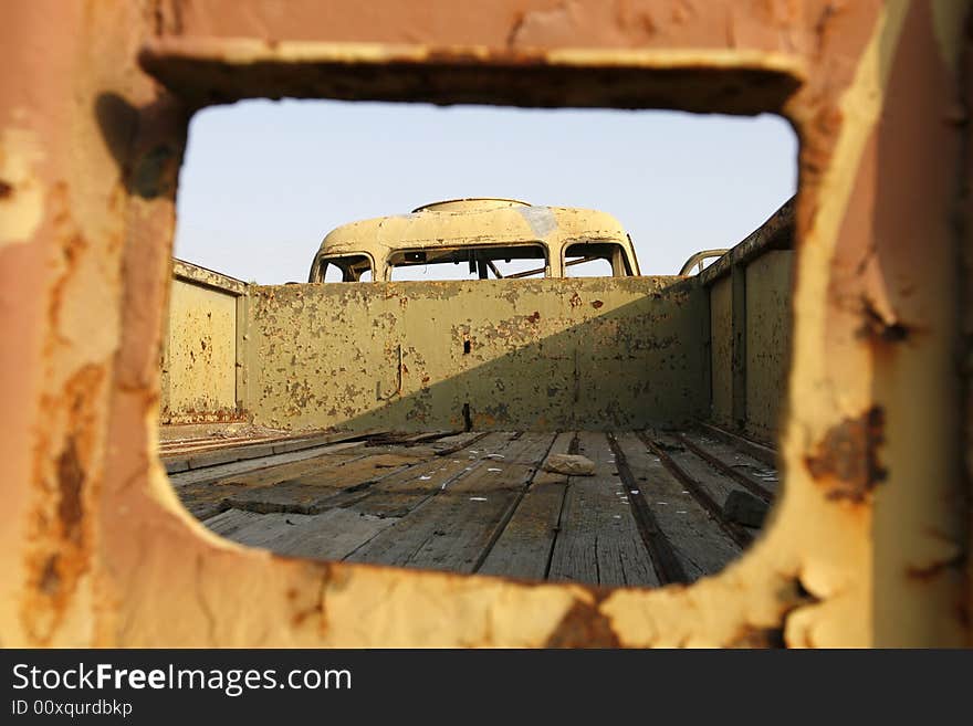 An old wreckage military car in a field. An old wreckage military car in a field