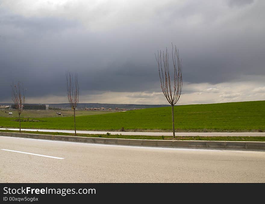 Green fields, the grey sky and white clouds