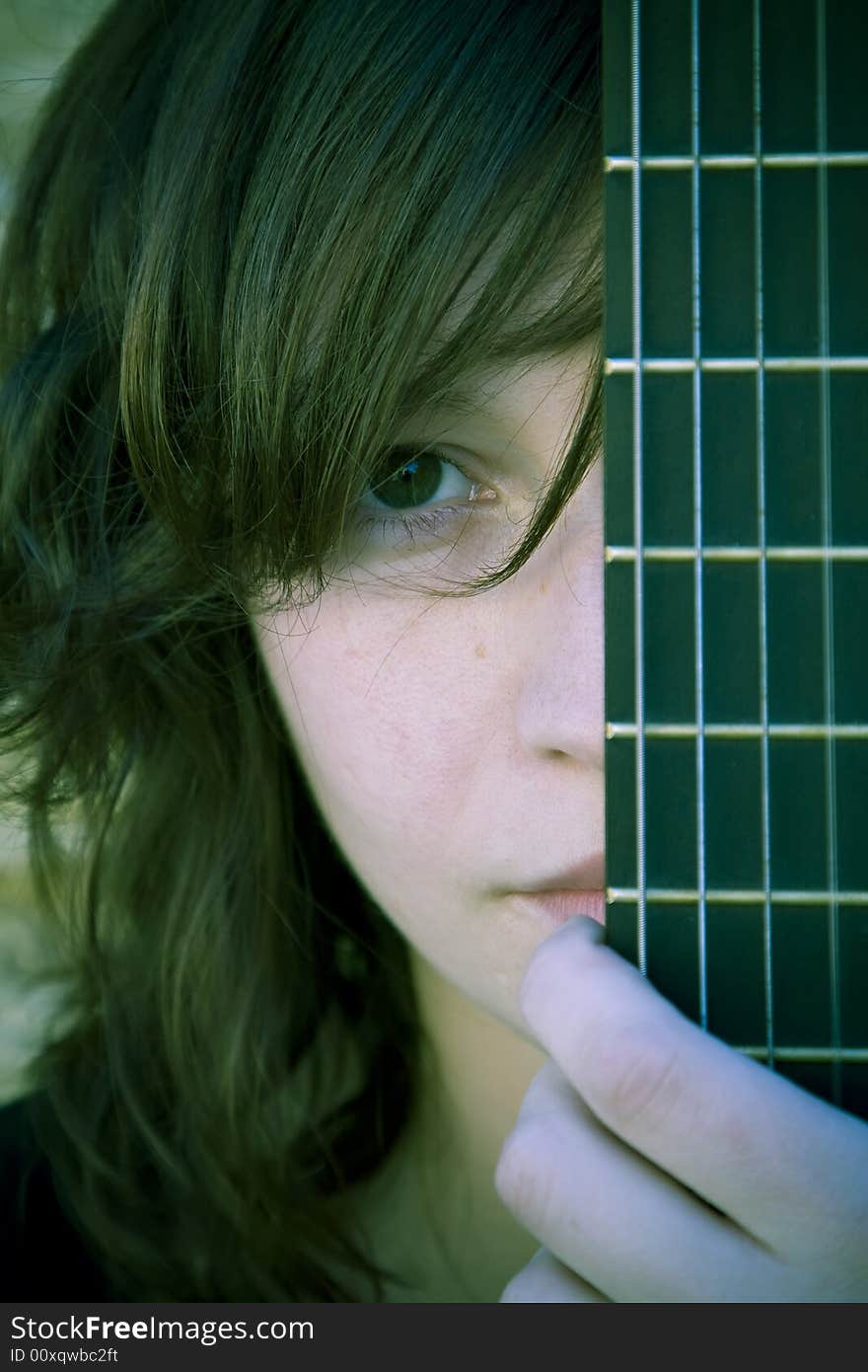 Woman behind guitar fretboard